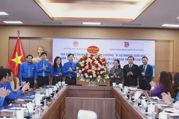 Lãnh đạo Bộ GD&ĐT tặng hoa chúc mừng đại diện Trung ương Đoàn nhân dịp kỷ niệm 94 năm Ngày thành lập Đoàn TNCS Hồ Chí Minh. Ảnh: Báo Giáo dục và thời đại