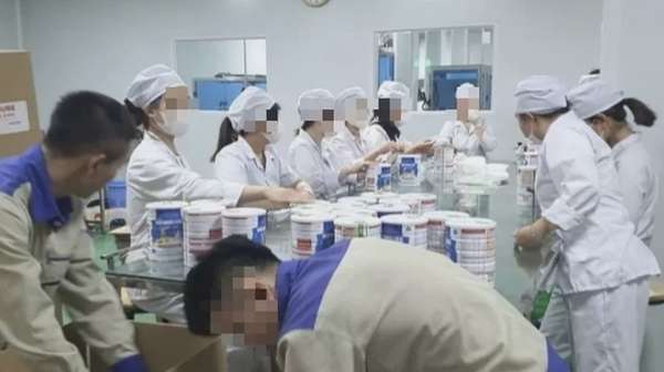 Công nhân đóng hộp thành phẩm tại cơ sở sản xuất sữa bột giả quy mô lớn vừa bị Công an thành phố Hà Nội triệt phá. (Ảnh: Báo Công an nhân dân)