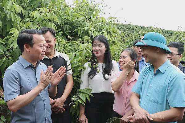 Bộ trưởng Đỗ Đức Duy trò chuyện, đồng thời gợi mở một số giải pháp sản xuất vải thiều hướng đến xuất khẩu tại xã Phúc Hòa, huyện Tân Yên, chiều 11/5. Ảnh: N.H