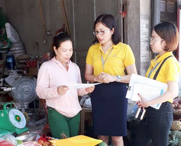 Cán bộ Bưu điện TP Cẩm Phả tuyên truyền, hướng dẫn người dân về chính sách BHXH tự nguyện tại chợ Cẩm Thạch (TP Cẩm Phả)