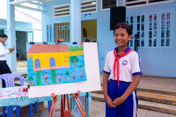 Anh Thơ bên bức tranh do em tự vẽ về ước mơ có nhà vệ sinh sạch, an toàn tại trường học. Ảnh: UNICEF Việt Nam