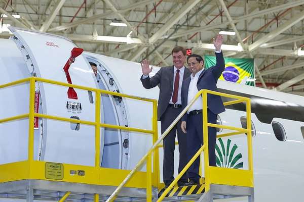 Chủ tịch kiêm Tổng Giám đốc Tập đoàn Embraer Francisco Gomes Neto cùng Thủ tướng Phạm Minh Chính thăm khu trưng bày các dòng máy bay và cơ sở hạ tầng sản xuất hiện đại của Embraer. Ảnh: Dương Giang/TTXVN