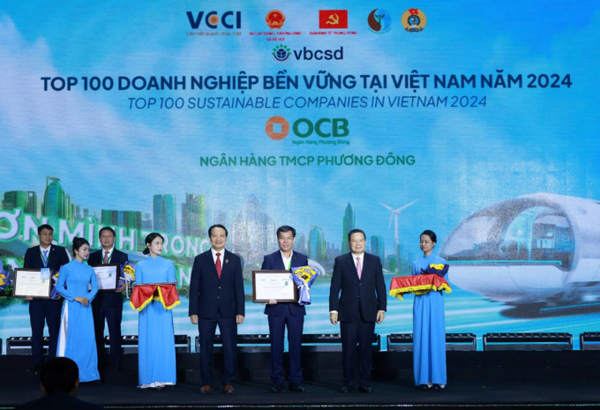 Đại diện OCB nhận hoa và giấy chứng nhận tại lễ vinh danh trong top 100 doanh nghiệp bền vững Việt Nam 2024