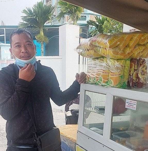 Anh Lê Trọng Huy bên cạnh cửa hàng bánh mì anh mới mở nhờ trúng giải thưởng triệu phú khi giải khát với Trà Xanh Không Độ trong hè 2023. (Ảnh NVCC)