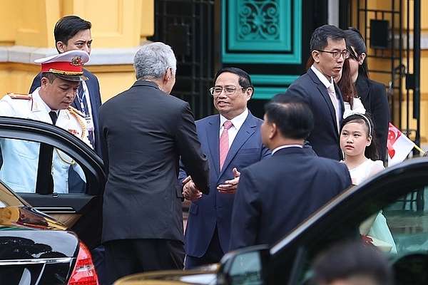Thủ tướng Phạm Minh Chính đón Thủ tướng Singapore Lý Hiển Long tại xe - Ảnh: VGP/Nhật Bắc