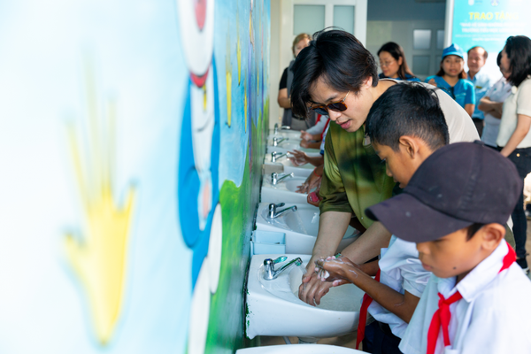 Hà Anh Tuấn và các học sinh sử dụng công trình nhà vệ sinh & nước sạch mới xây dựng – một trong những kết quả đầu tiên của Innovation for Children. Ảnh: UNICEF Việt Nam