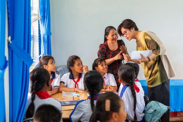 Giáo viên trường Tiểu học Long Phú C giải thích cho Hà Anh Tuấn về các tiết học ứng dụng sáng kiến Thư viện số Toàn cầu của UNICEF. Ảnh: UNICEF Việt Nam