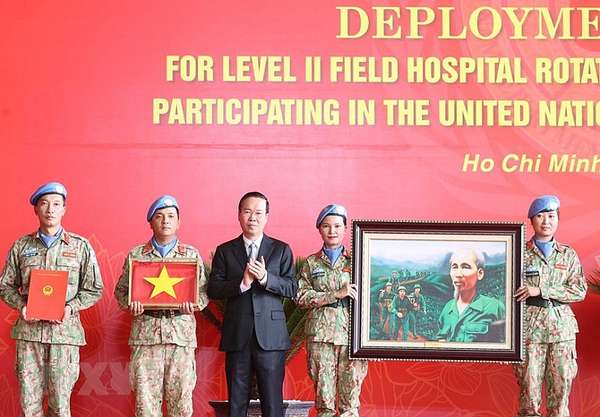 Chủ tịch nước Võ Văn Thưởng trao quyết định và tặng cờ Tổ quốc cùng bức tranh 'Bác đang cùng chúng cháu hành quân' cho các lực lượng lên đường làm nhiệm vụ.