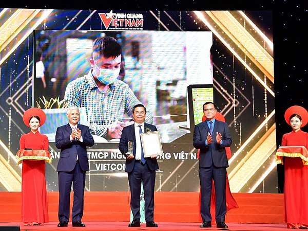 Chủ tịch UBTW MTTQ Việt Nam Đỗ Văn Chiến (bên trái) trao Biểu trưng và Chủ tịch Tổng LĐLĐ Việt Nam Nguyễn Đình Khang (bên phải) trao Chứng nhận vinh danh cho ông Nguyễn Thanh Tùng - Tổng giám đốc đại diện tập thể Vietcombank